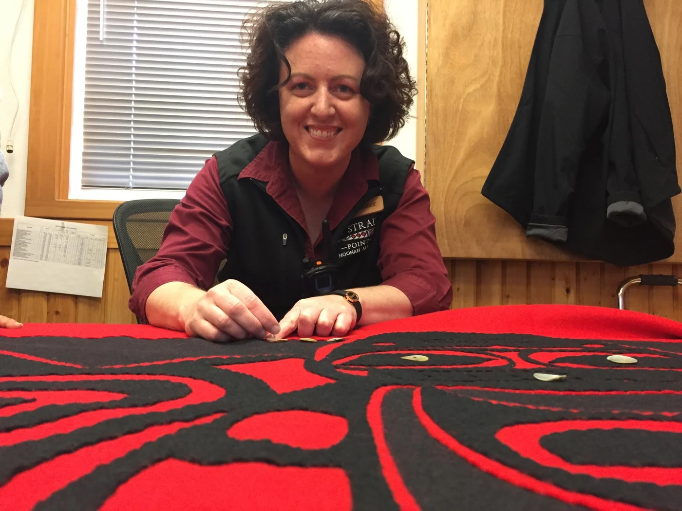 Tourism professional working with a formline-design textile at Icy Strait Point